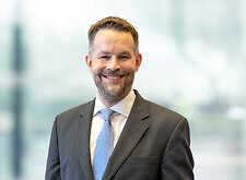 Kevin Harkins on light blue and white bokeh banner