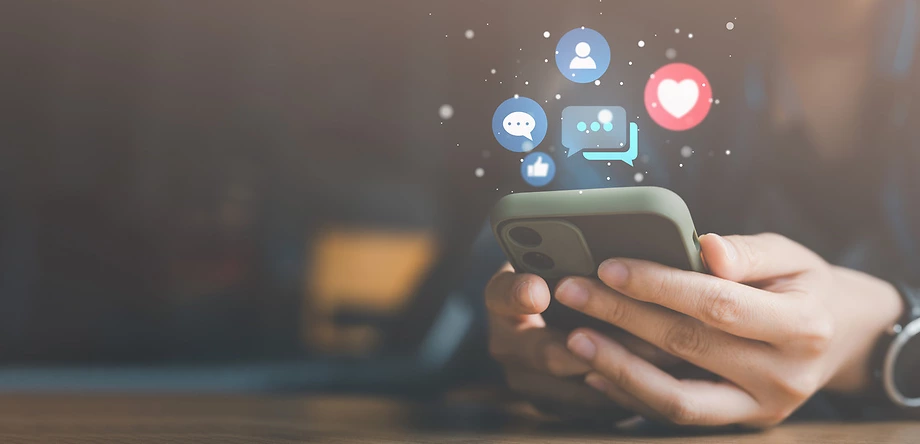 Person holding phone with social Media Interactions Icons popping up