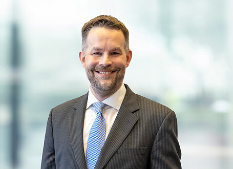 Kevin Harkins on light blue and white bokeh banner