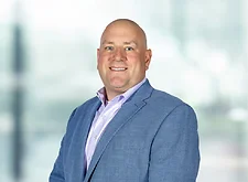 Charles Malcomb on light blue and white bokeh banner