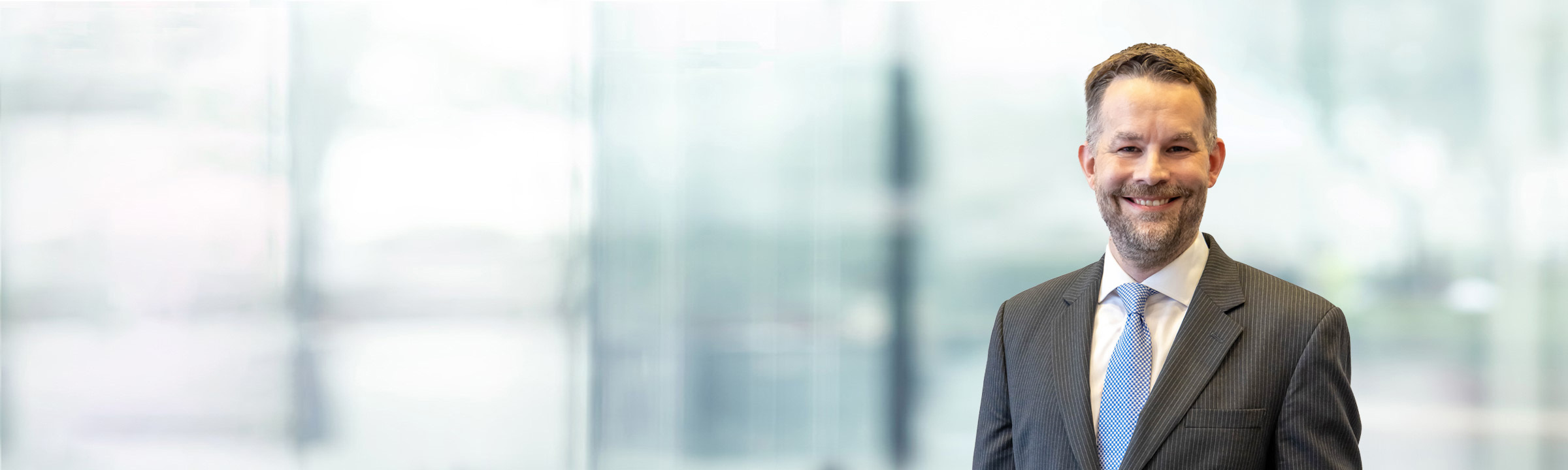 Kevin Harkins on light blue and white bokeh banner