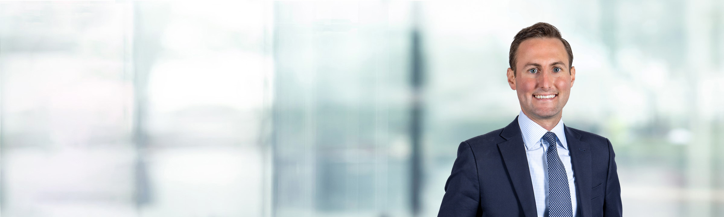 Patrick Owens on light blue and white bokeh banner