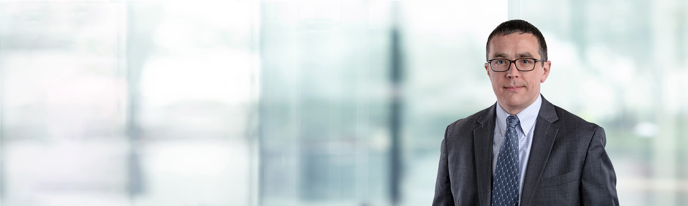 Than Lucek on light blue and white bokeh banner