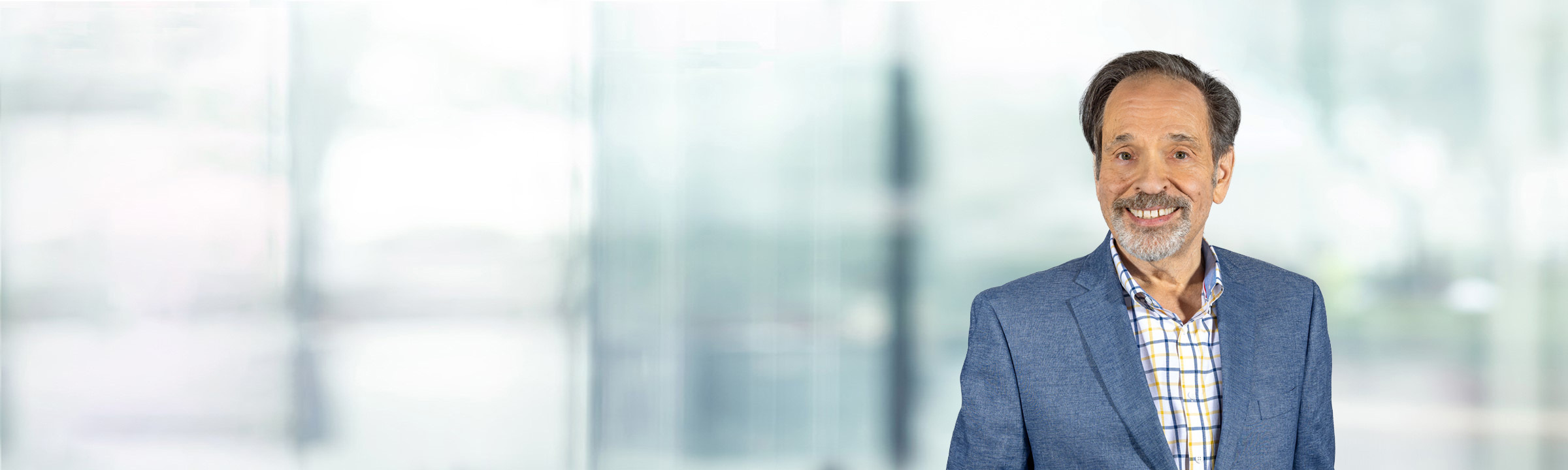 Mark Klein on light blue and white bokeh banner